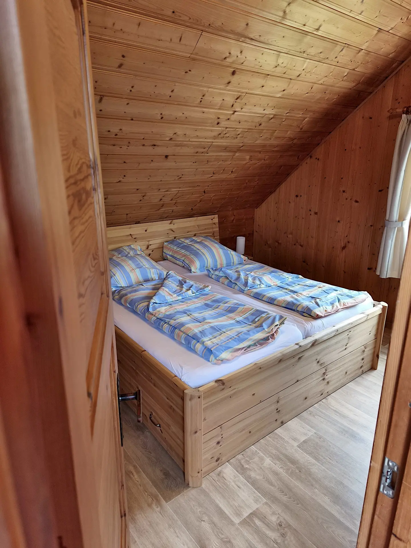 großes Schlafzimmer mit Doppelbett, Kinderbett, Fernseher und Kleiderschrank