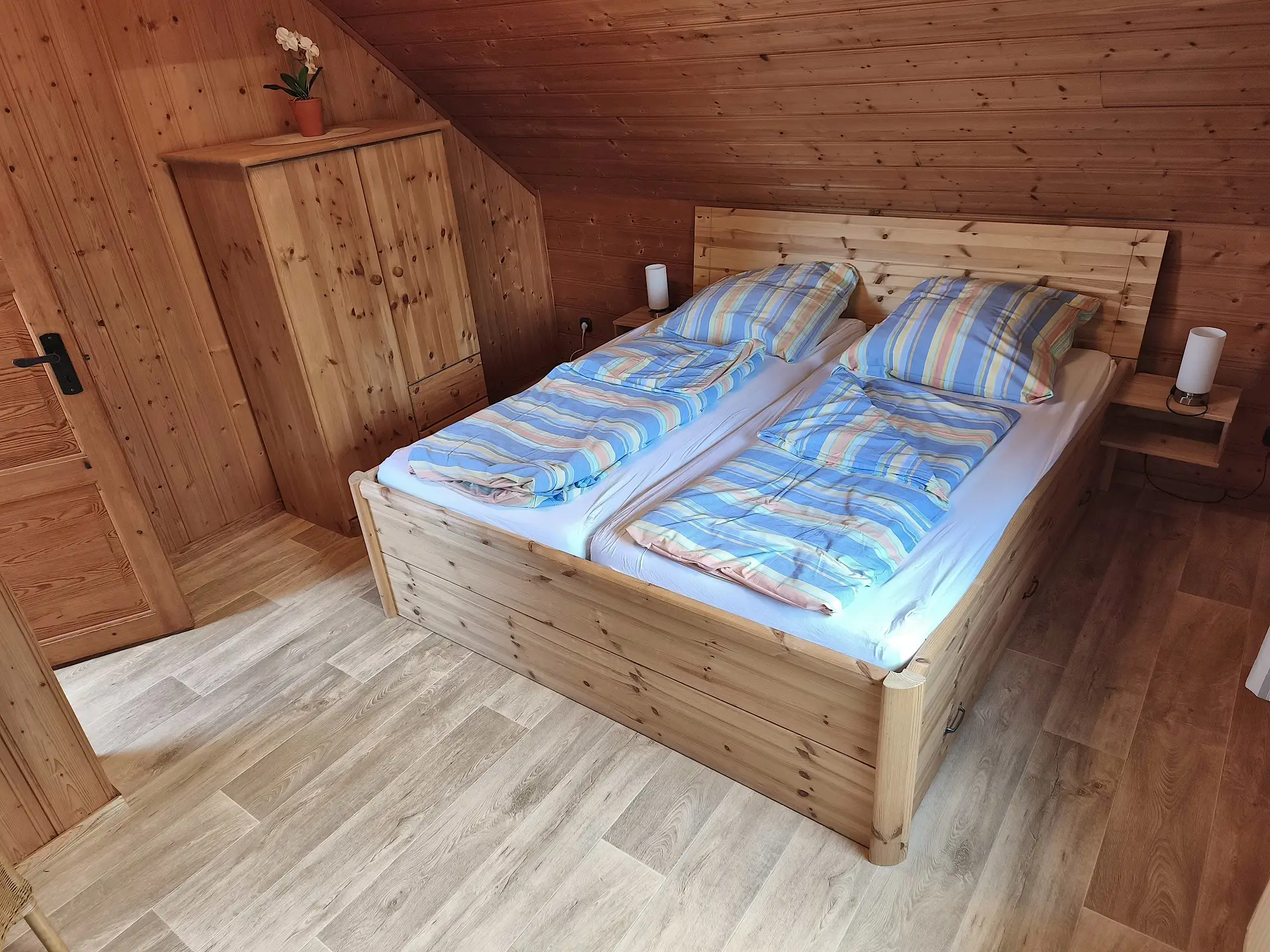 großes Schlafzimmer mit Doppelbett, Kinderbett, Fernseher und Kleiderschrank